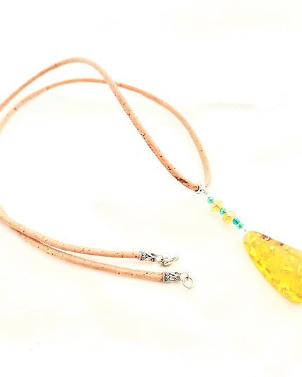 tropfenförmiger, honigfarbener Bernstein an einer ca. 80 cm langen Kordel aus Kork. Im Bernstein sind wunderschöne Einschlüsse, die ihm eine interessante Optik verleihen. Handmade by Tikiwe-Taschen aus Kork