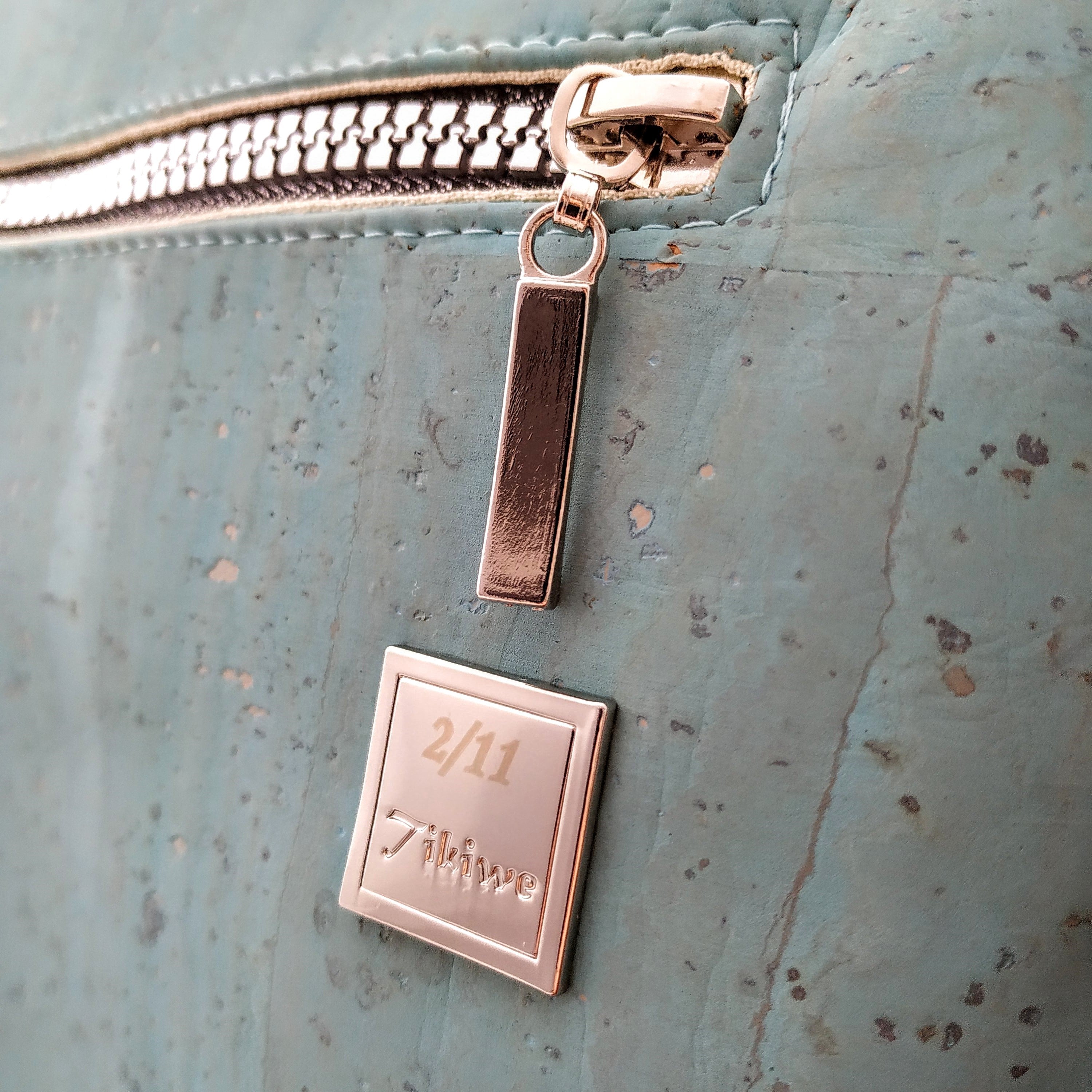 Logo Tikiwe®-Taschen aus Kork, silberfarben auf türkisem Kork