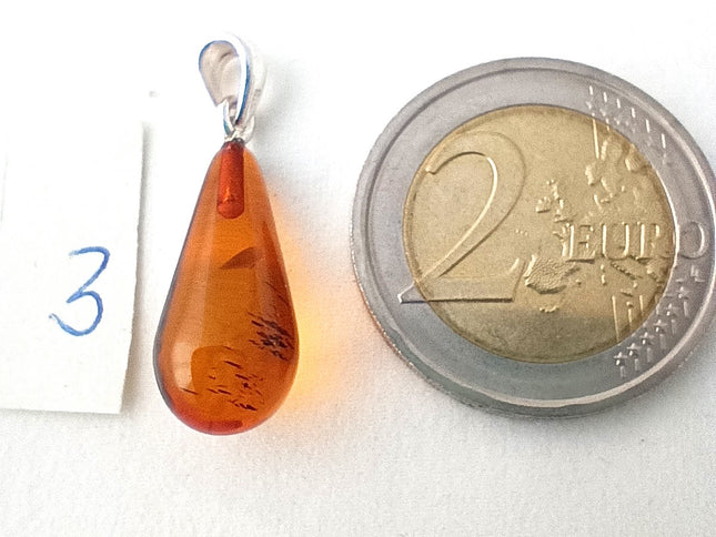 Bernsteintropfen 3 kurz mit 2 Euromünze als Größenvergleich