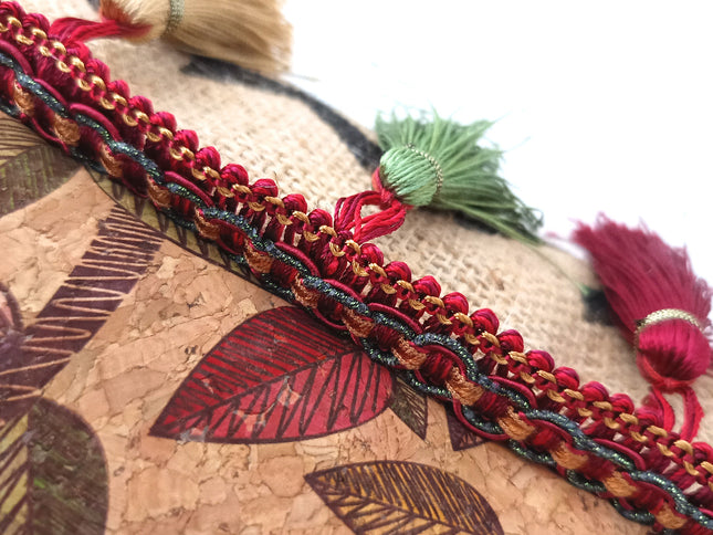 Detailaufnahme der Bordüre mit den Quasten Farben rot grün gold 
Kaffeesack und der mit Blättern bedrucke Kork