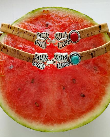 2 Choker / Armbänder aus Kork mit einer Schmetterlingschließe und rotem, türkisem Stein auf eine Melone