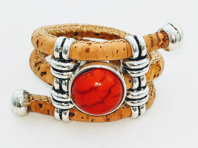 3-reihiger Ring aus weichem, naturfarbenem Kork mit einem Mittelstein aus roter Presskoralle und 2 silberfarbenen Stegen. Passt für alle Größen.